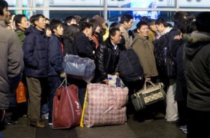 Milhões de trabalhadores migrantes chineses esperam na fila para embarcar em trens. Foto de Peijin Chen.