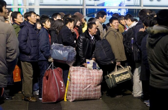 Milhões de trabalhadores migrantes chineses esperam na fila para embarcar em trens. Foto de Peijin Chen.