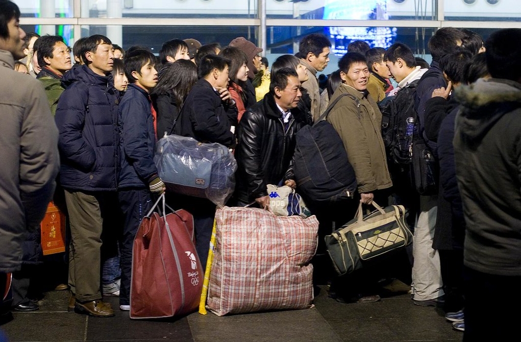 Milhões de trabalhadores migrantes chineses esperam na fila para embarcar em trens. Foto de Peijin Chen.